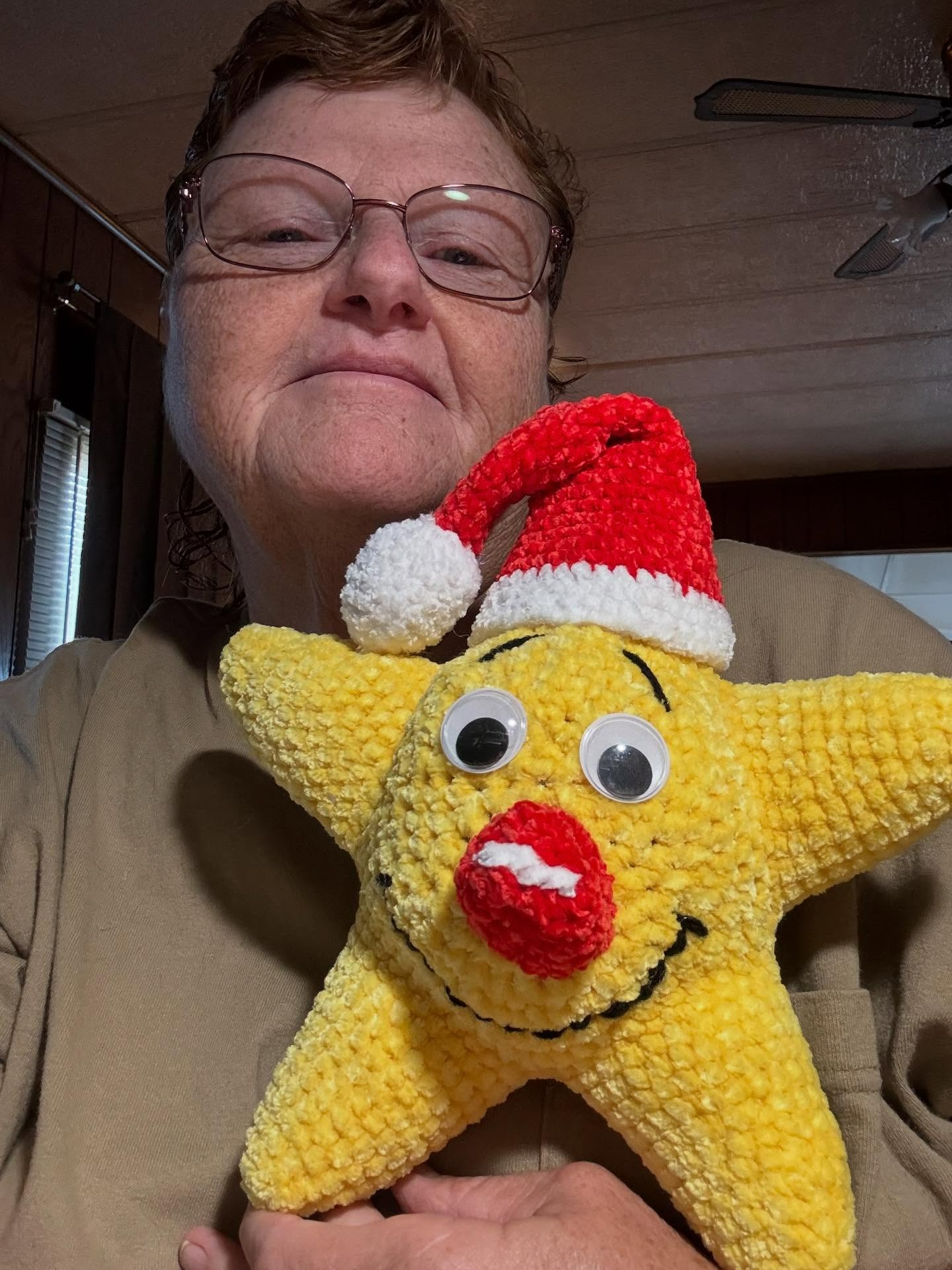 Deanna Schwindt holding one of her handmade crochet star plushies